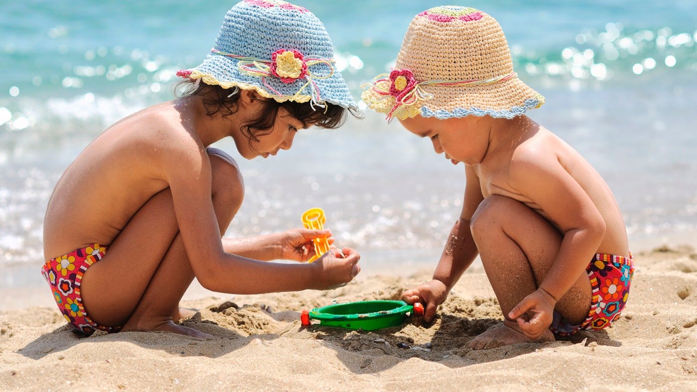 Barn på stranden, sommer og sol og lek