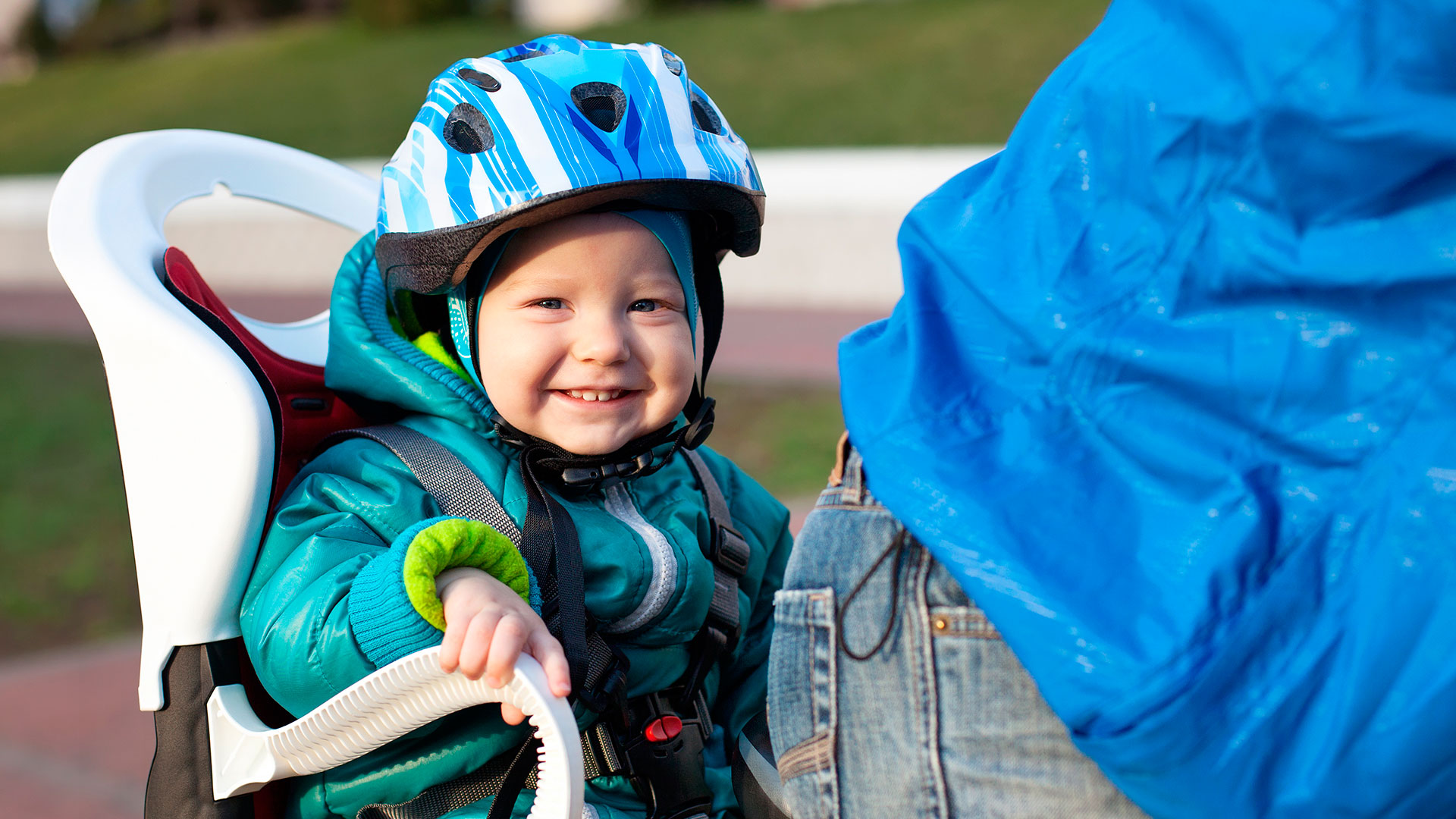 Bilde av et barn i barnesete på en sykkel.