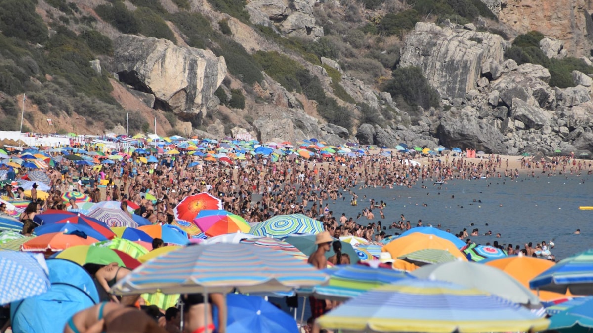 Masse mennesker på stranden på sommeren