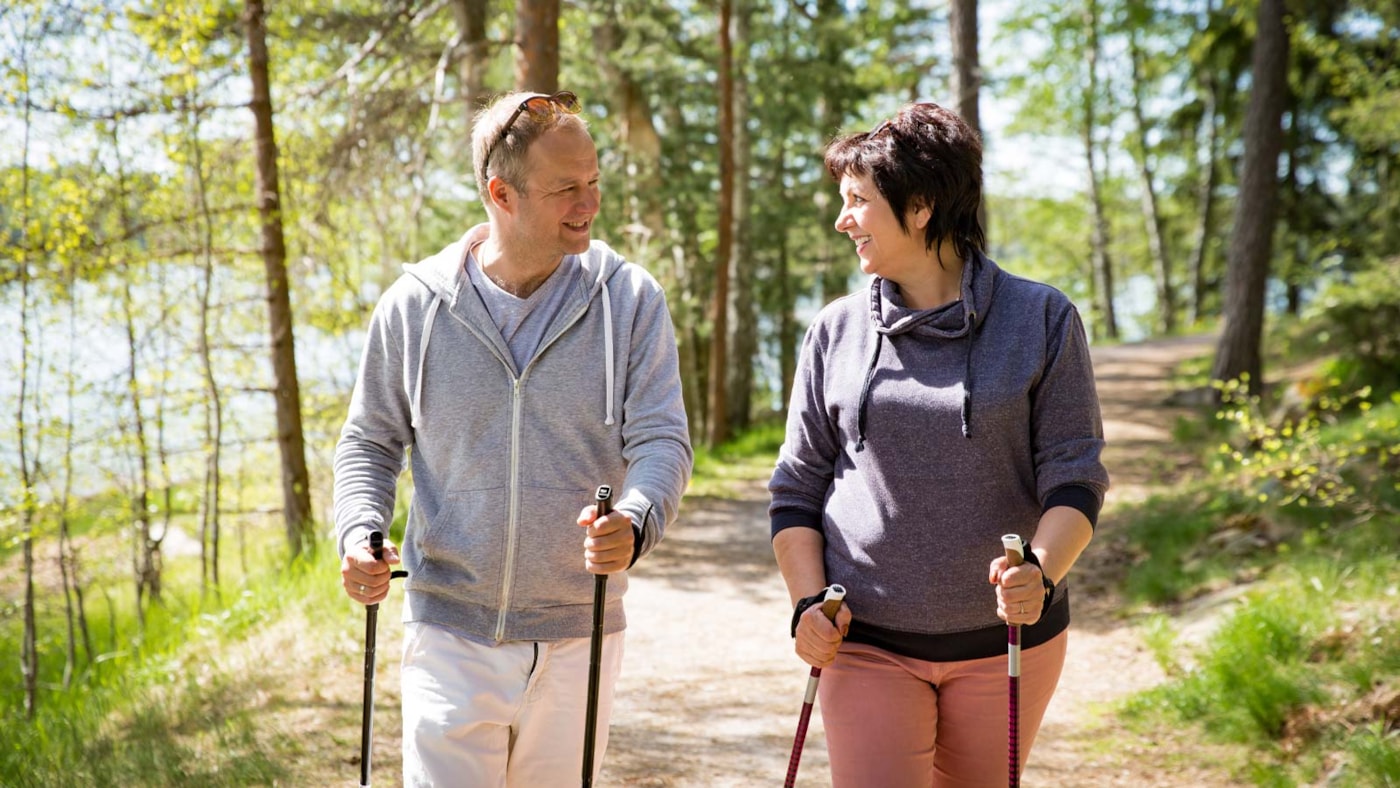 Par på tur, med staver, i skogen